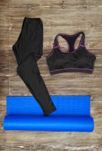 Woman's yoga outfit on wooden background